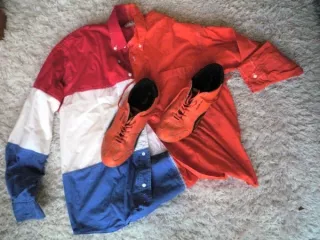 Blouse in kleuren van de Nederlandse vlag met oranje schoenen er bovenop